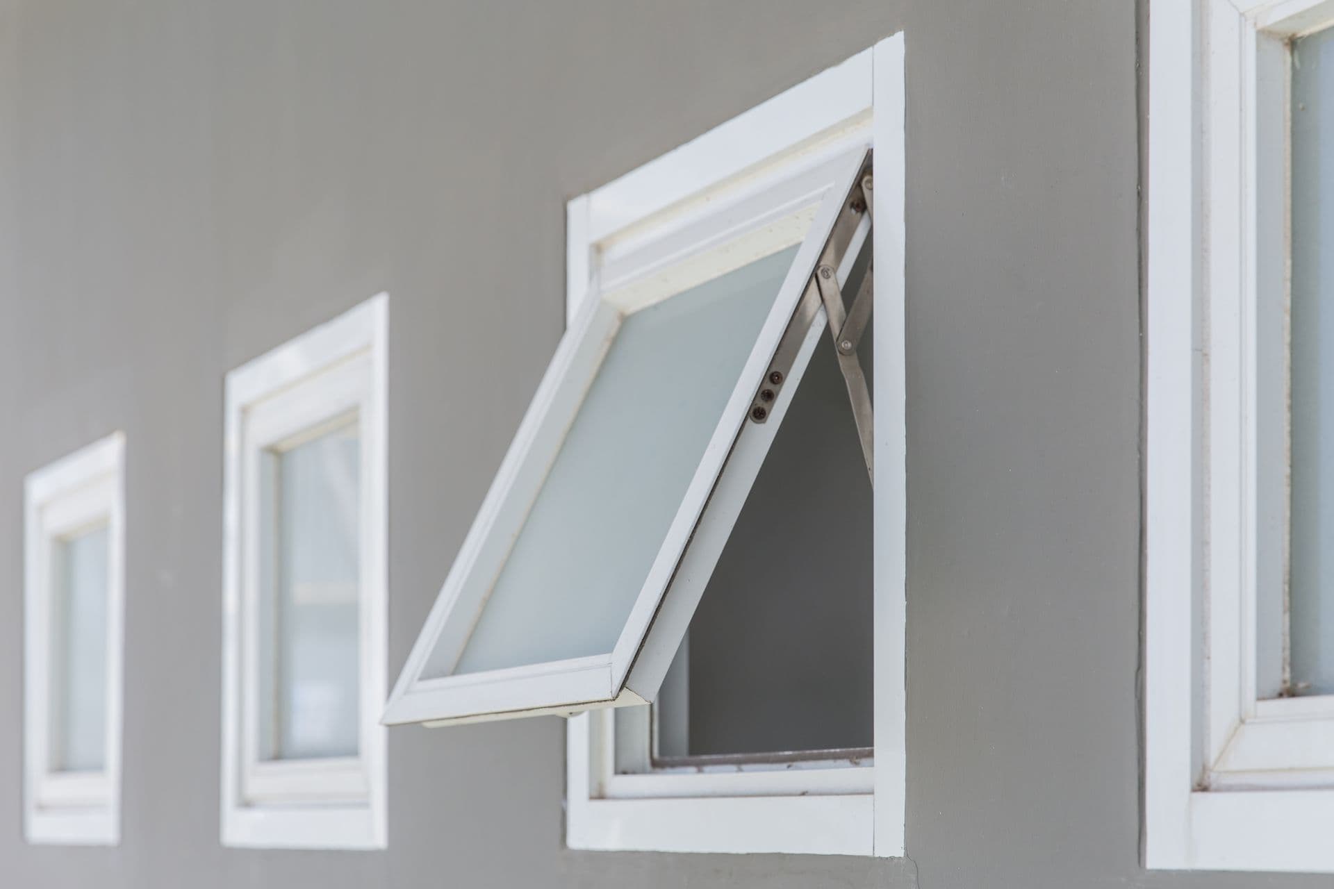 An open awning window as viewed from the outside.